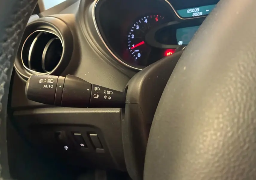 Gros plan sur la commande des phares et clignotants à gauche du volant du Renault Captur bleu, tableau de bord en arrière-plan.