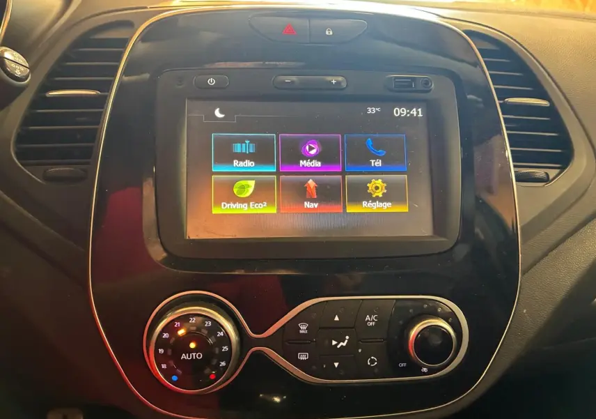 Vue rapprochée du tableau de bord du Renault Captur 2017, avec écran tactile multimédia et commandes de climatisation.