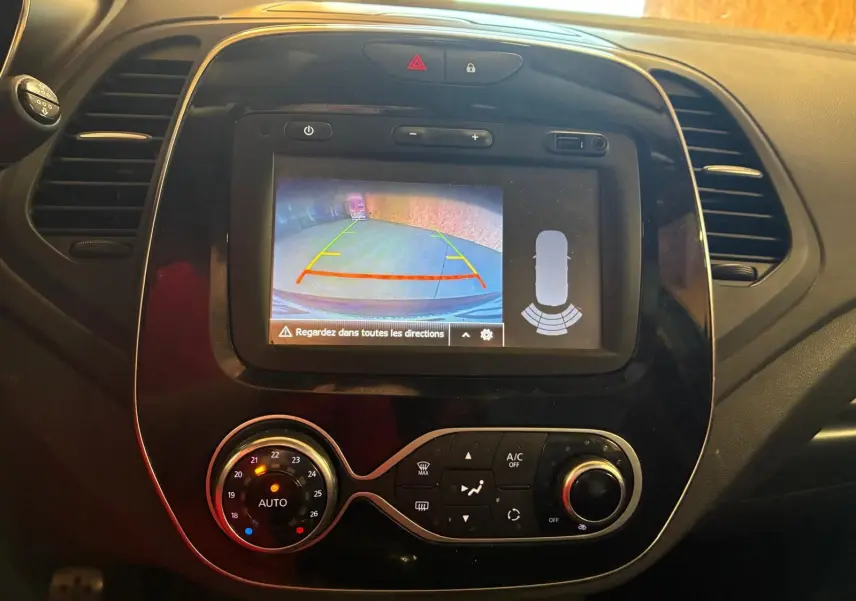 Vue rapprochée de l’écran central du Renault Captur 2017 montrant la caméra de recul et les commandes de climatisation.