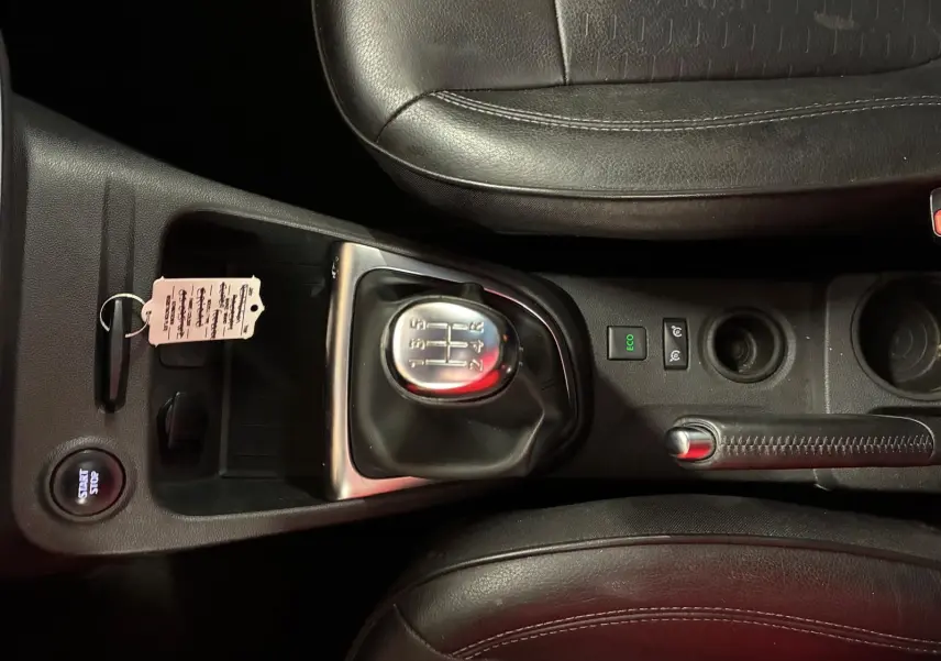 Vue rapprochée de la console centrale du Renault Captur bleu 2017, montrant levier de vitesse manuel et frein à main en cuir noir.