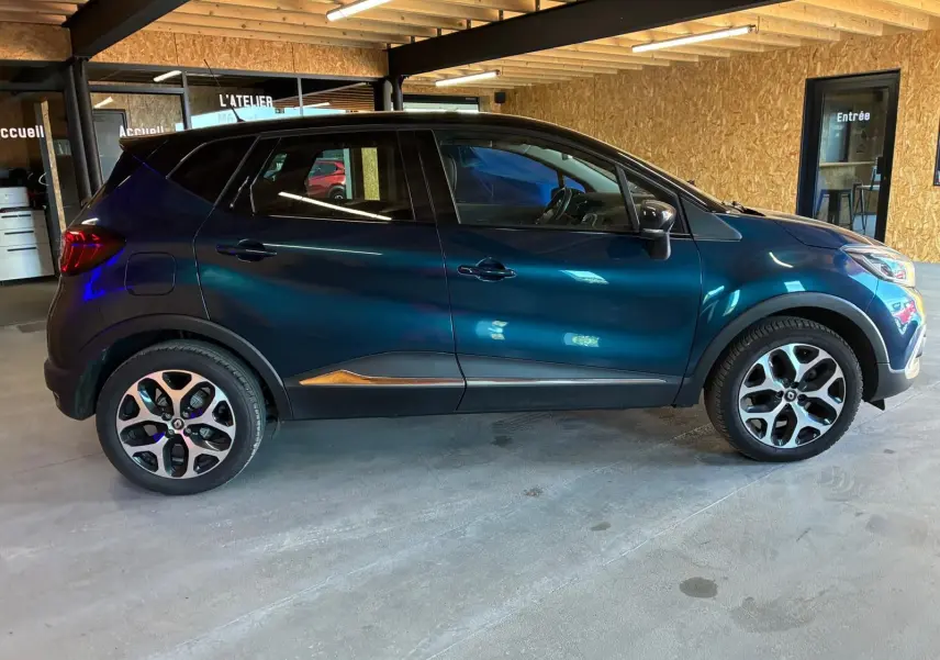 Renault Captur 1.5 DCI 90 Intens bleu en profil droit, avec jantes alliage et détails noirs contrastants.