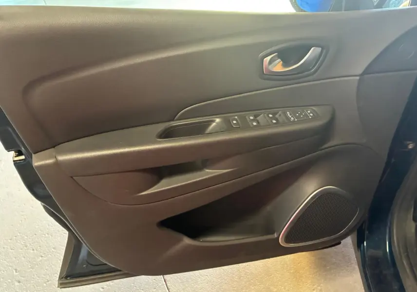 Vue rapprochée de la porte avant gauche du Renault Captur bleu 2017, avec commandes de vitres et haut-parleur intégré.