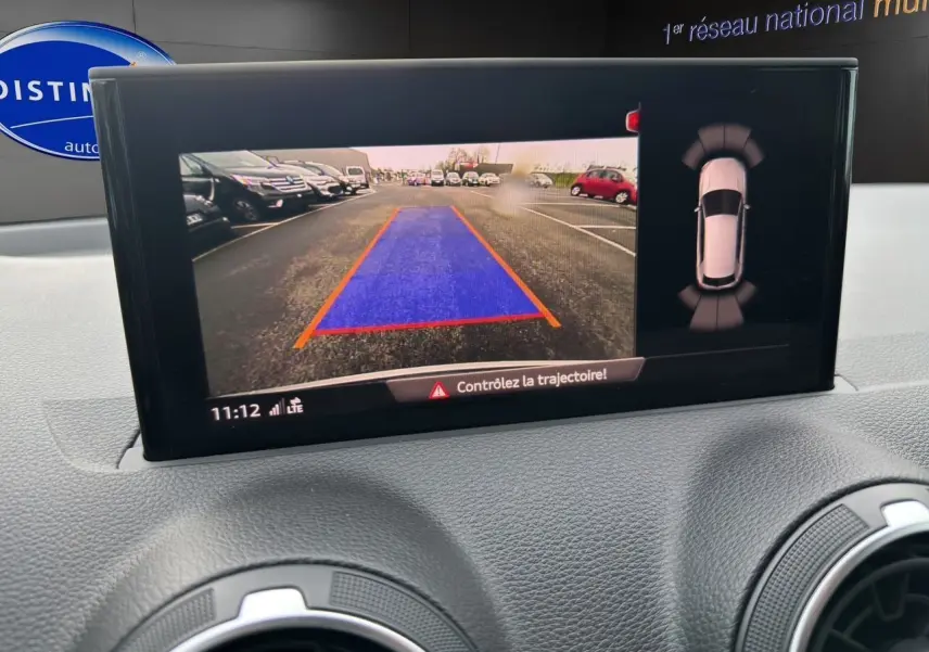 Écran central montrant la caméra de recul et l'aide au stationnement du tableau de bord d'un Audi Q2 noir Mito.