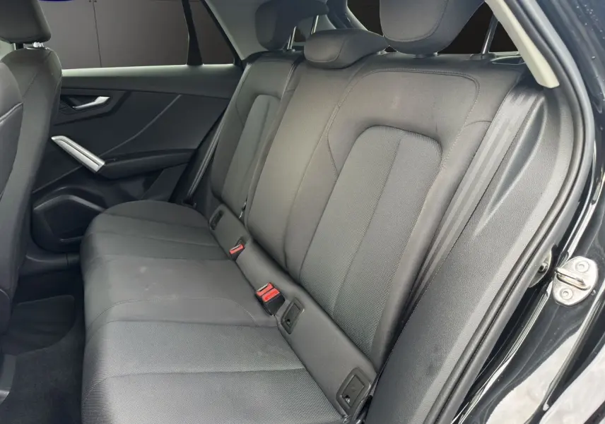 Vue intérieure côté droit des sièges arrière en tissu noir du SUV Audi Q2 35 TFSI S-Line 2023.