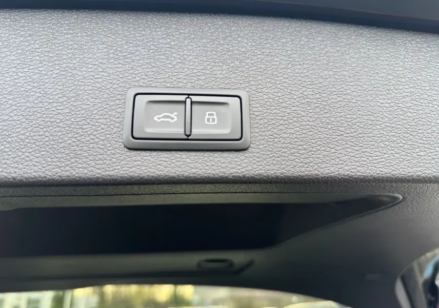 Boutons d'ouverture hayon motorisé et verrouillage sur le bord intérieur du hayon noir du Audi Q2 35 TFSI 2023.