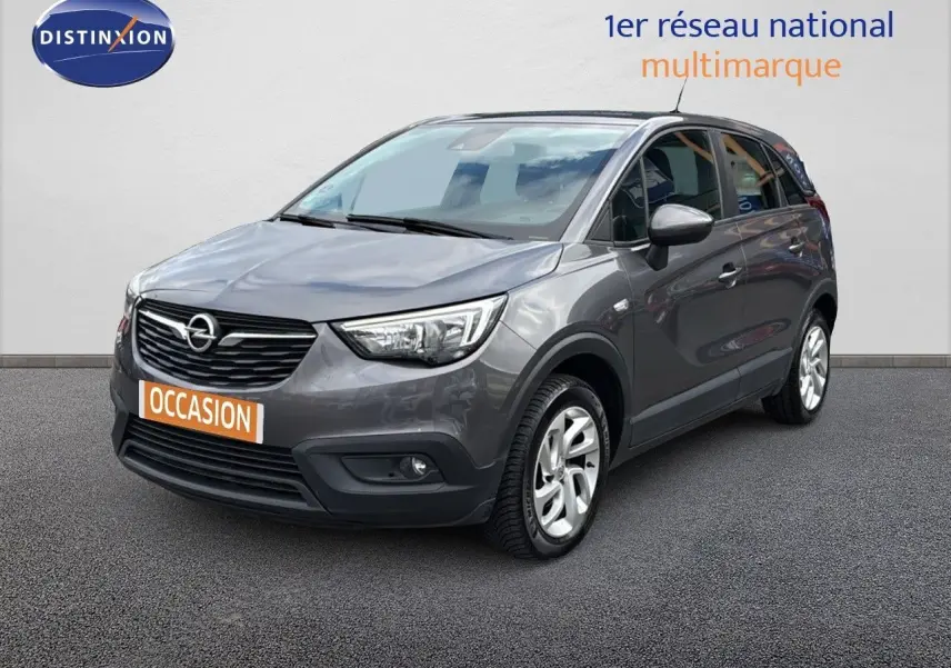 Opel Crossland X gris pierre de lune métal en 3/4 avant droit avec calandre noire et jantes argentées.