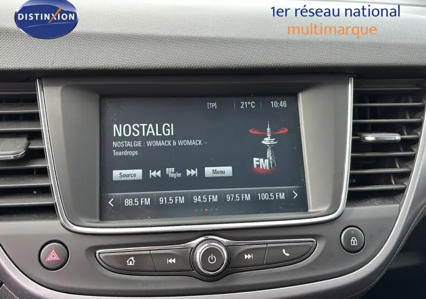 Tableau de bord de l'Opel Crossland X 2020, écran central affichant une radio FM, entouré de commandes noires et grises.
