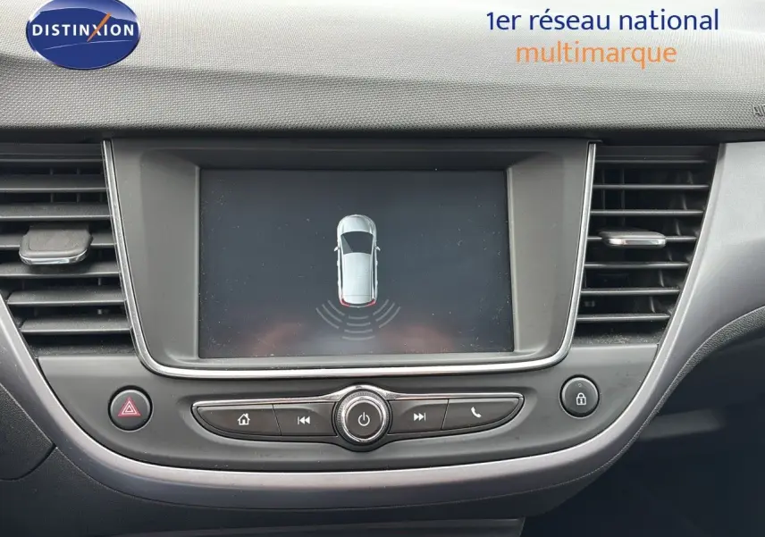 Vue rapprochée de l'écran central et des commandes du tableau de bord d'une Opel Crossland X gris pierre de lune métal.