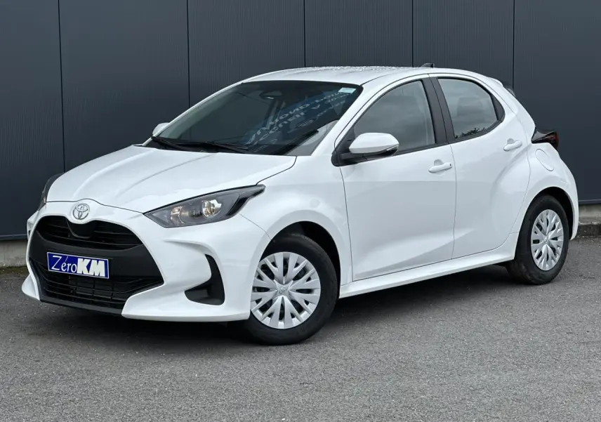Toyota Yaris hybride blanc pur vue 3/4 avant droit avec calandre noire et jantes acier à enjoliveurs.