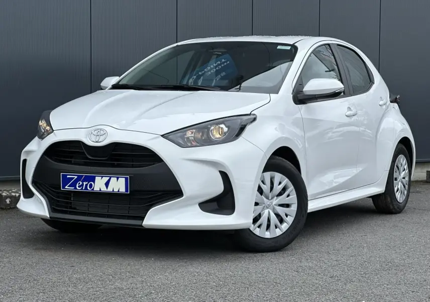 Toyota Yaris hybride blanc pur vue 3/4 avant droit avec calandre noire et jantes acier à enjoliveurs.