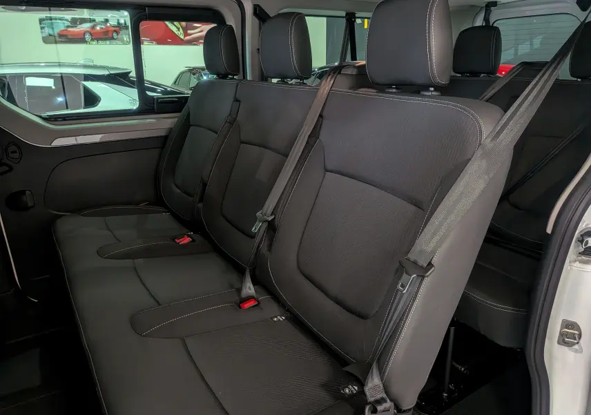 Vue intérieure côté droit des sièges arrière noirs en tissu du Renault Trafic Combi blanc Glacier 2025.