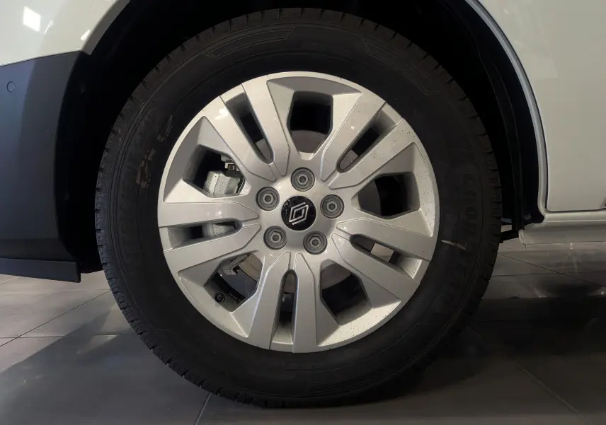 Gros plan sur la roue avant droite du Renault Trafic Combi blanc Glacier avec jante alliage et pneu Goodyear.