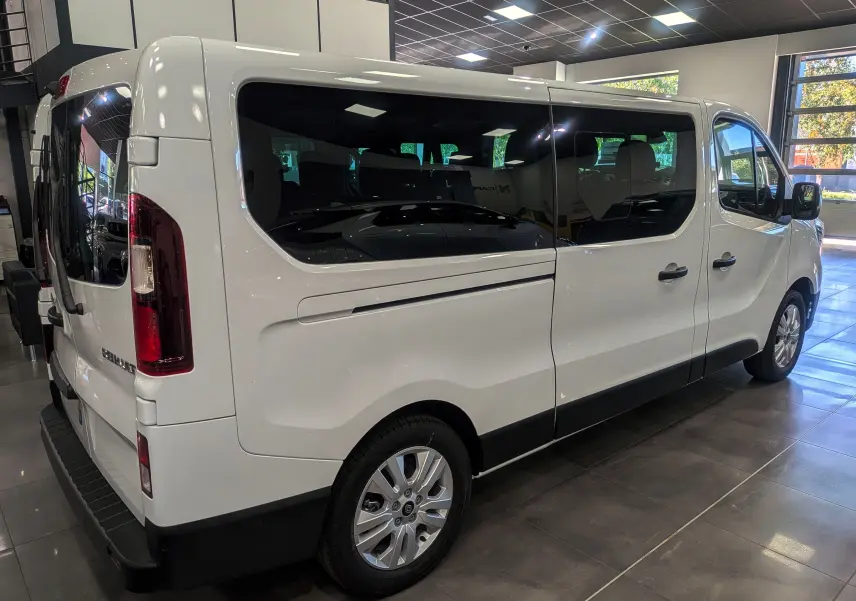 Renault Trafic Combi blanc glacier vu de trois quarts arrière droit, avec vitres teintées et jantes alliage.