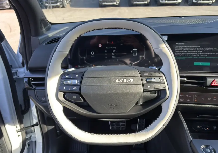 Vue rapprochée du volant cuir blanc nacré du Kia Sportage 2026 avec tableau de bord numérique et écran tactile.
