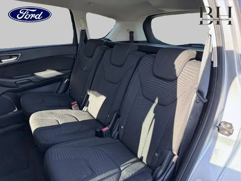 Vue intérieure côté droit des sièges arrière noirs du Ford S-MAX gris lunaire avec trois appuie-têtes et ceinture de sécurité.