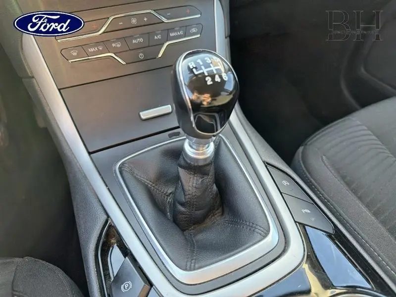 Gros plan sur le levier de vitesses manuel noir et cuir dans l'habitacle gris du Ford S-MAX 2016.