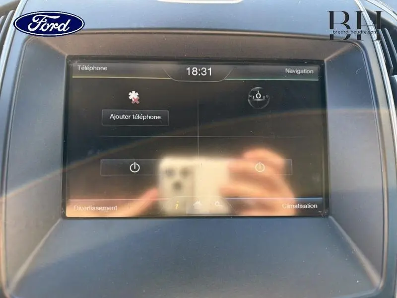 Écran tactile central du Ford S-MAX 2016 affichant le menu téléphone et navigation, avec reflets visibles.