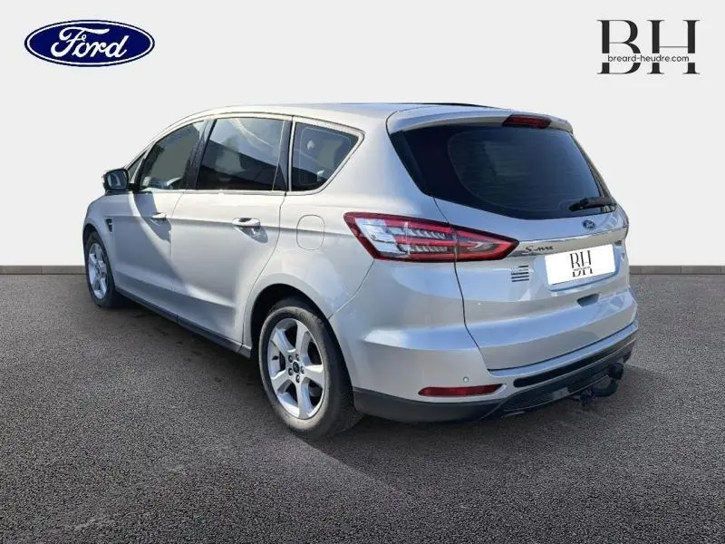 Vue 3/4 arrière droit d'un Ford S-MAX gris lunaire avec vitres teintées et jantes alu cinq branches.