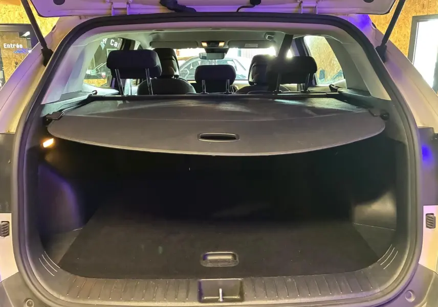Vue arrière du coffre ouvert du KIA Sportage gris 2024, montrant l'espace de chargement avec cache-bagages déployé.
