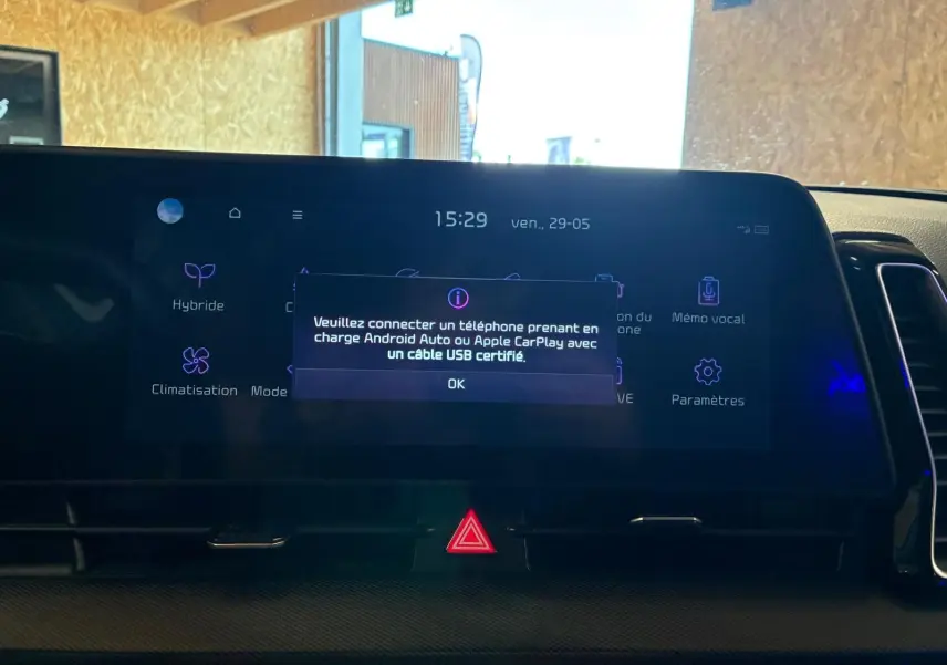 Vue rapprochée de l’écran tactile du tableau de bord du Kia Sportage gris 2024, affichant un message de connexion USB.
