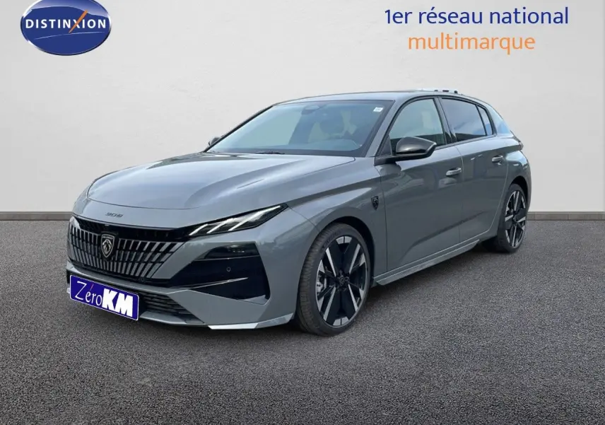 Peugeot 308 gris selenium métal vue 3/4 avant droit, avec calandre distinctive et jantes noires bicolores.
