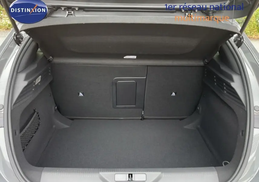 Coffre ouvert vu de l'arrière d'une Peugeot 308 gris selenium metal, espace de rangement propre et spacieux.