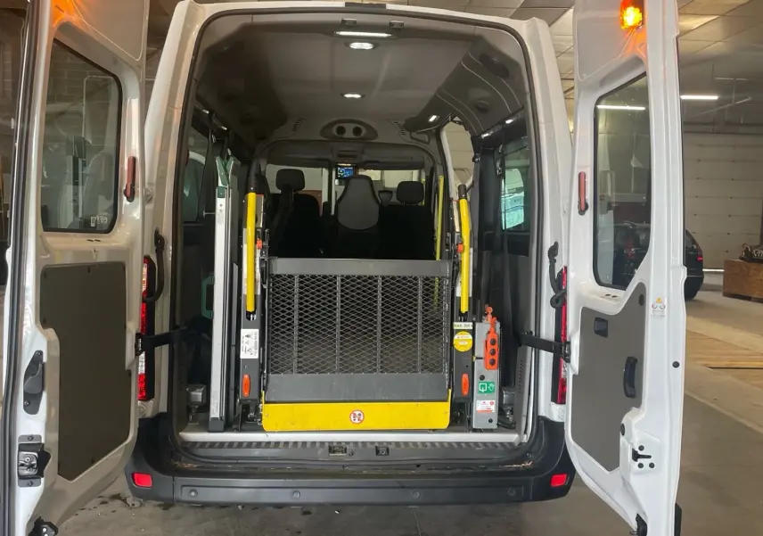 Vue arrière du Renault Master blanc avec portes ouvertes, mettant en valeur la rampe d'accès pour fauteuil roulant.