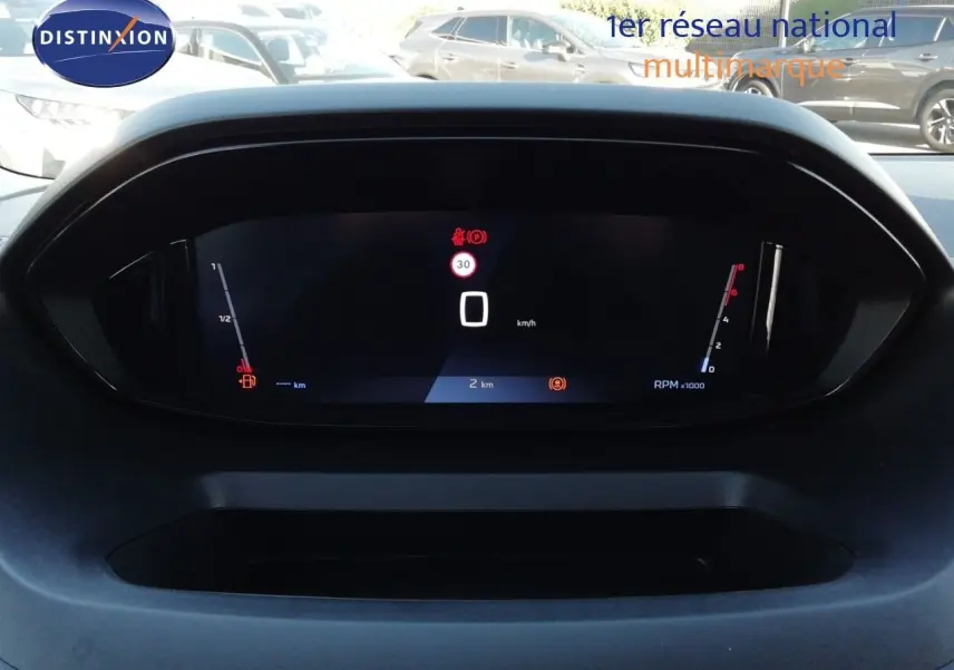 Vue rapprochée du tableau de bord numérique du Peugeot Partner blanc Kaolin 2026, affichant la vitesse à 0 km/h.
