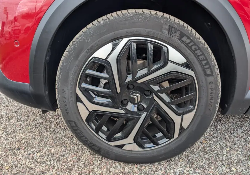 Gros plan sur la jante alliage 18'' Aeroblade noire et argentée du côté gauche d'une Citroën C4 rouge foncé 2024.