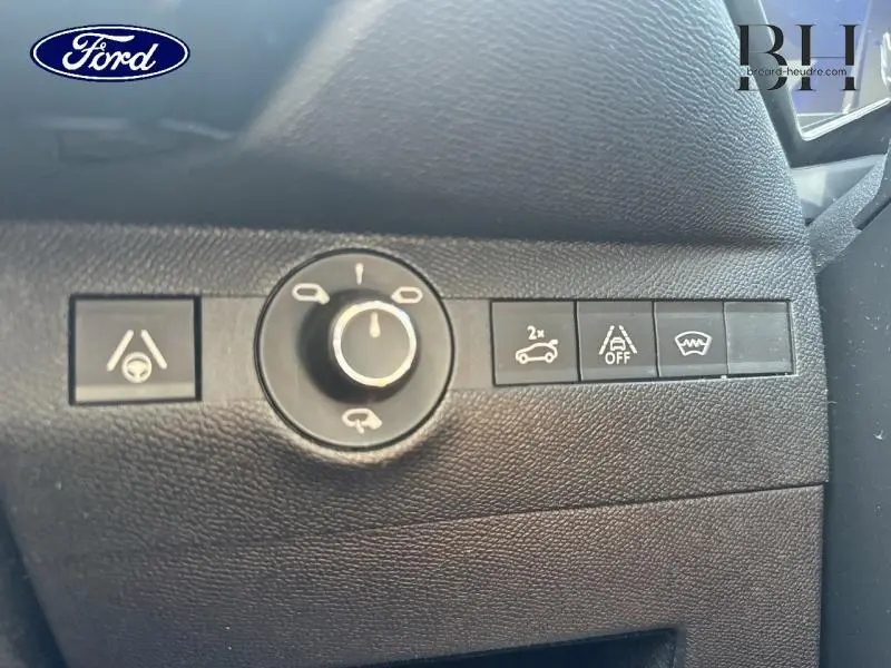 Panneau de commandes noir côté conducteur avec boutons d’assistance et réglage des rétroviseurs, intérieur Ford.