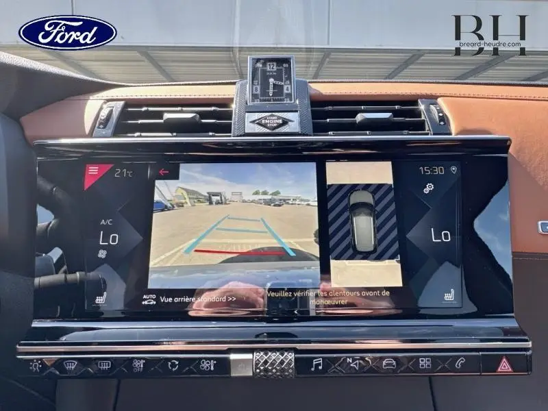 Vue rapprochée de l’écran tactile central du DS7 Crossback gris Artense avec affichage caméra de recul et horloge digitale.