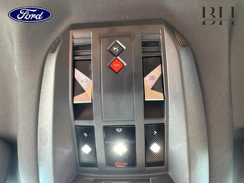Vue en plongée sur la console de plafonnier noire avec boutons SOS et éclairage du DS7 Crossback gris Artense.