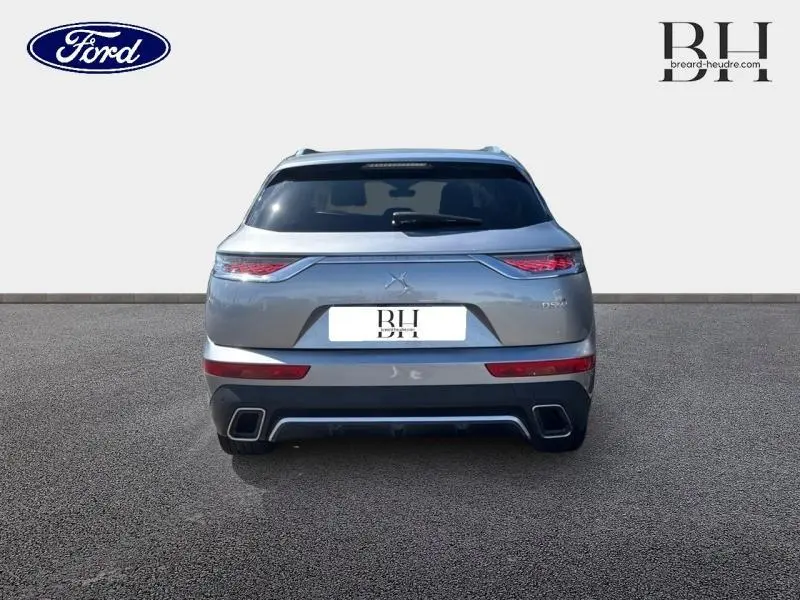 Vue arrière du DS7 Crossback gris Artense avec feux LED effilés et double sortie d'échappement rectangulaire.