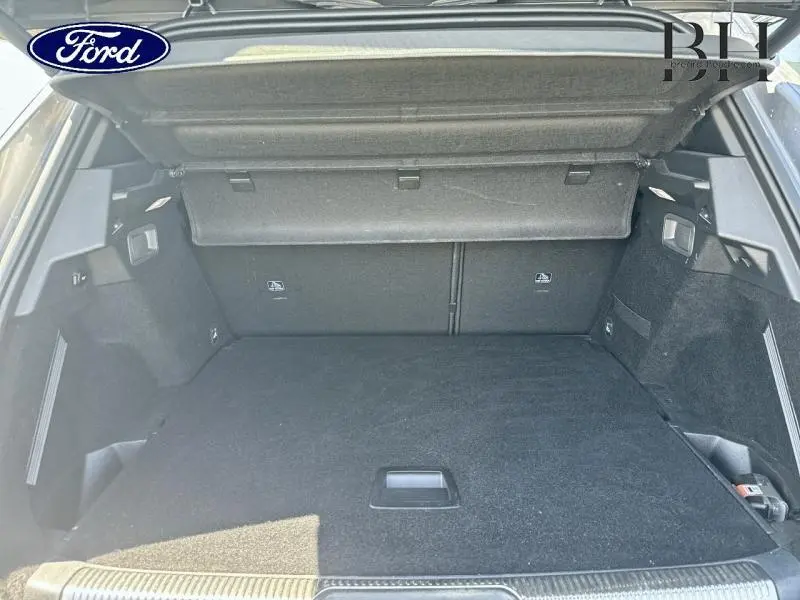 Coffre ouvert vu de l'arrière d'un DS7 Crossback gris Artense, montrant un espace de chargement propre et spacieux.