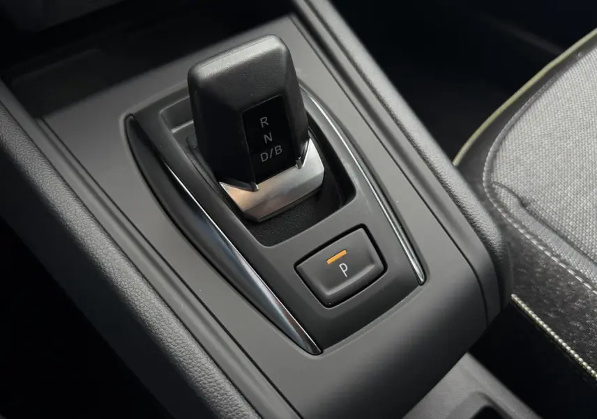 Gros plan sur la commande de boîte automatique noire du Renault Captur gris Rafale, avec bouton de stationnement éclairé.
