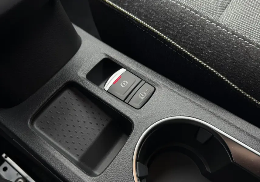 Gros plan sur la console centrale noire du Renault Captur 2026 avec boutons frein électrique et auto-hold.
