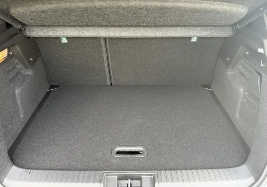 Coffre spacieux du Renault Captur gris Rafale, vue intérieure arrière avec plancher de coffre mobile fermé.