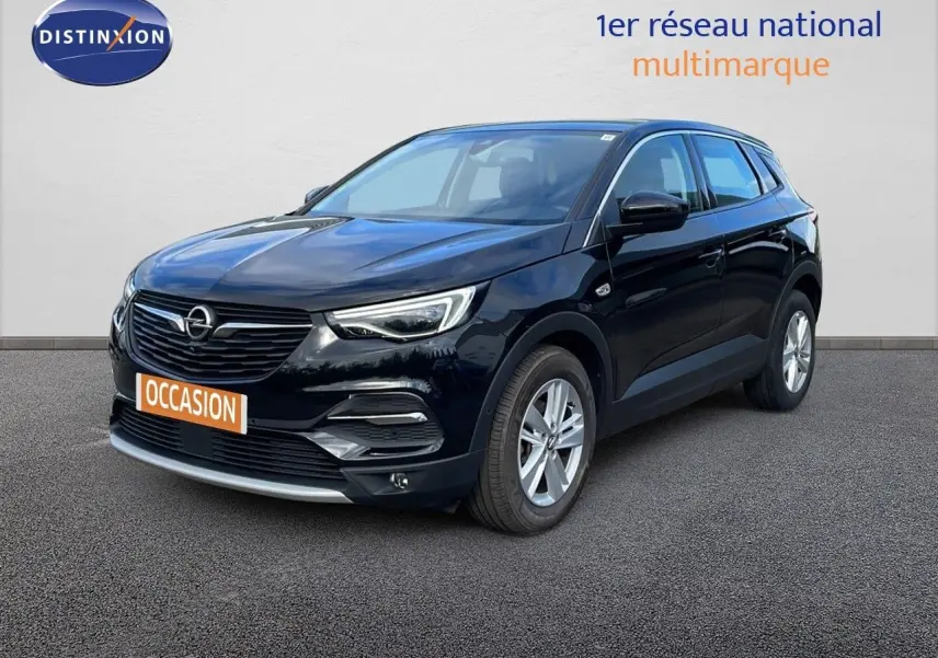 Opel Grandland X noir diamant métal en 3/4 avant droit sur sol gris, avec calandre et phares LED visibles.