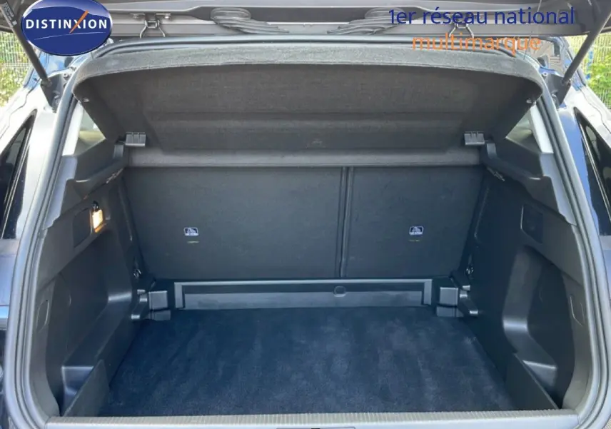 Coffre ouvert vu de l'arrière d'un Opel Grandland X noir diamant métal, montrant un espace de chargement propre et spacieux.