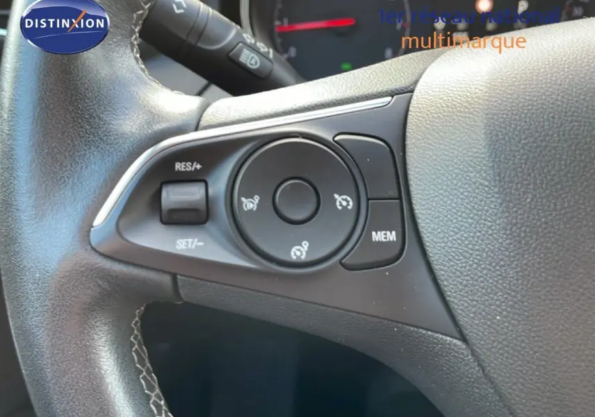 Gros plan sur les commandes de régulateur de vitesse au volant cuir noir de l’Opel Grandland X 2021.