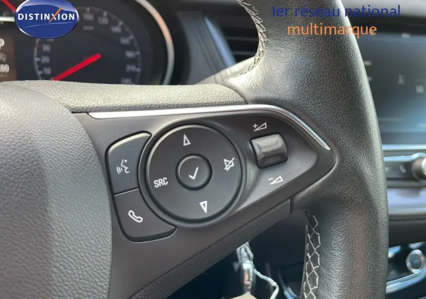 Gros plan sur le volant en cuir noir de l’Opel Grandland X 2021, avec commandes audio et téléphone intégrées.