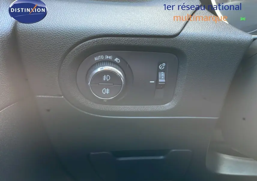 Gros plan sur le tableau de bord noir de l'Opel Grandland X 2021, montrant la commande des phares et réglage de luminosité.