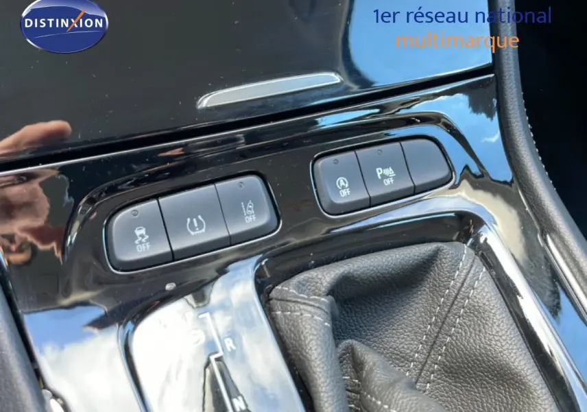 Gros plan sur la console centrale noire brillante de l’Opel Grandland X 2021, montrant les boutons de contrôle et le levier de boîte automatique.