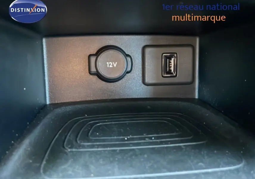 Prise 12V et port USB en gros plan dans le compartiment de rangement intérieur de l’Opel Grandland X noir diamant métal.