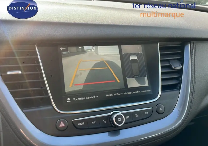 Vue intérieure du tableau de bord de l’Opel Grandland X noir diamant, écran affichant la caméra de recul et l’aide au stationnement.