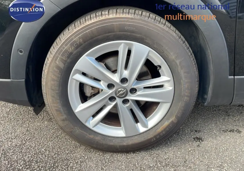 Gros plan sur la roue avant gauche de l'Opel Grandland X noir diamant métal avec jante alliage 17 pouces.