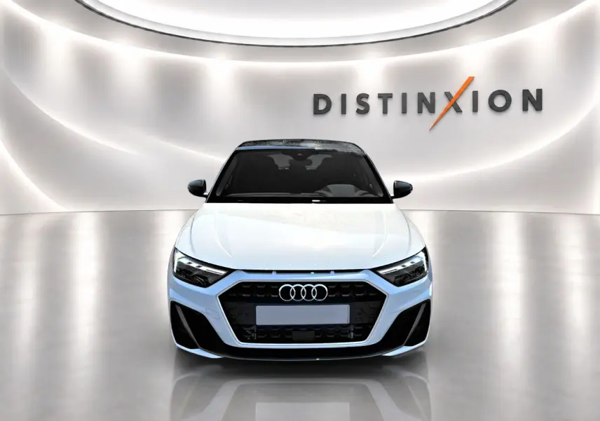 Audi A1 Sportback blanc et noir vue de face dans un showroom avec éclairage moderne et logo Distinxion en arrière-plan.