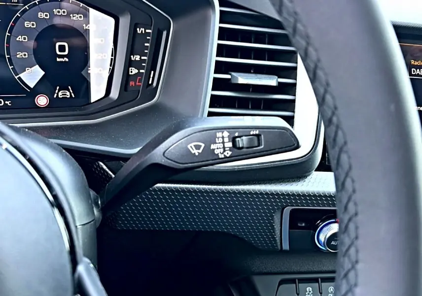 Vue rapprochée du tableau de bord et du volant noir de l’Audi A1 Sportback 2026 avec écran digital et commandes au volant.