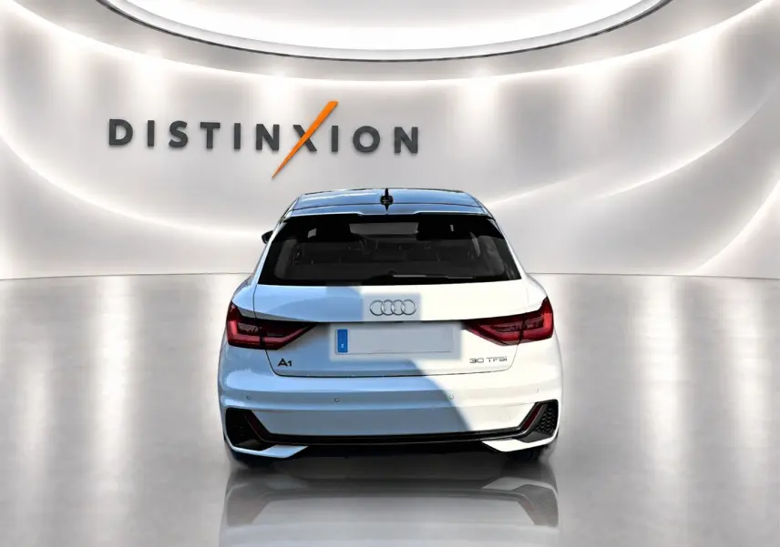 Vue arrière d'une Audi A1 Sportback 30 TFSI blanche avec toit noir, dans un showroom lumineux au logo Distinxion.