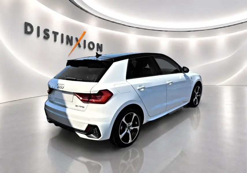 Audi A1 Sportback blanc toit noir en 3/4 arrière droit, avec jantes alliage et becquet arrière sportif.